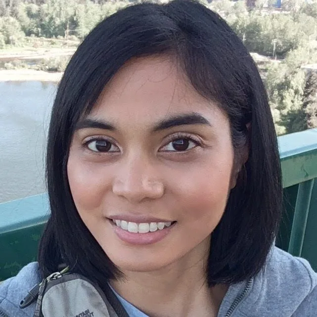 Staff - Ellen Reyes&#039;s picture. She is posing for a selfie in balcony with lake in her background.